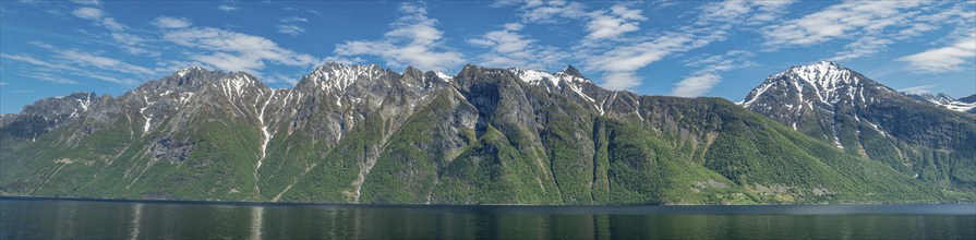 Panorama, east cost of fjord Hjørundfjord north of Urke, steep snowcovered mountains, no roads cut