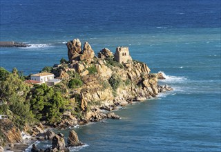 Ruins of Torre Caldura Castle on a rocky promontory jutting into the sea near Cefalu, Sicily,