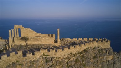 Drone shot, Acropolis of Lindos, late afternoon light, Temple of Athena Lindia, ruins on a rocky