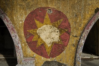 A ruined wall with a faded red and yellow star symbol on it, Italian Governor's Palace, Ruins,