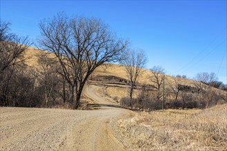 Winding gravel road through the rolling hills of rural western Iowa is part of the Loess Hills