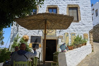 Restaurant with outdoor area, white walls, sunny tables and Mediterranean plants, Chora, Old Town,