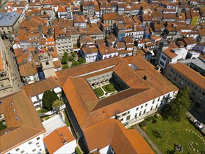 A view of an old town with many historic buildings and orange-coloured roofs, aerial view,