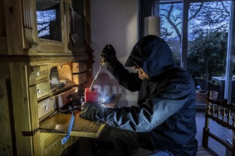 Symbolic image of a burglary, perpetrator has broken into a flat from the garden side and is