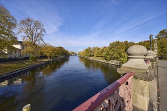 Luther bridge over the river Spree with Bellevue bank, autumnal trees and blue sky with