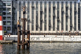 Young people diving into the harbour, Fisketorvet harbour swimming pool in Copenhagen, Denmark,