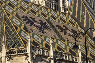 Coat of arms made of roof tiles on the roof of St Stephen's Cathedral in Vienna, Austria, Europe