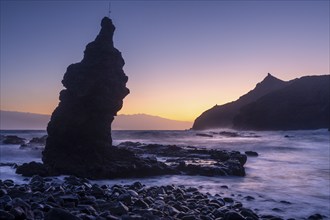 Sunrise on the beach at Playa de La Caleta with Punta San Lorenzo. Rocks and sea. Blue sky.