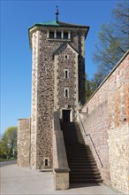 Old stone defence tower with stairs and wall, blue sky and trees in the background, defence tower,