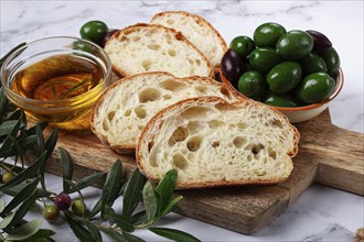 Appetizer, sliced ciabatta bread, with olive oil, green olives, Chalkidiki olives, classic Green