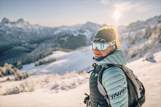 Summit bliss in the snow-covered winter landscape in the Tannheimer Tal in the Alps on the