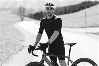 Road bike rider in spring near Halblech in the Allgäu in front of a picturesque backdrop of the