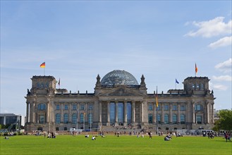 The Reichstag in Berlin with its striking glass dome and German flags on a large lawn, Reichstag