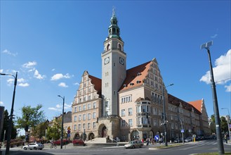 A historic town hall with tower and clock, surrounded by a lively street scene, Town Hall, Olsztyn,