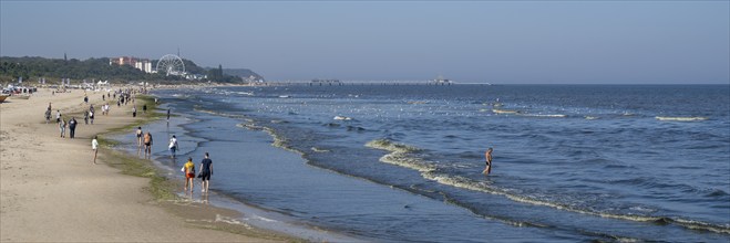 Tourists on the beach, behind the pier of Heringsdorf, Ahlbeck, Usedom Island, Baltic Sea,