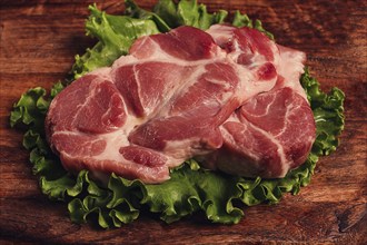 Raw pork steak, two pieces, on a wooden background