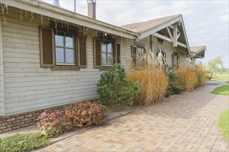 Modern restaurant with green lawn, tile path and landscape design with ornamental grasses and