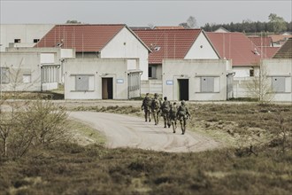 Soldiers walk into a training town, taken as part of a Bundeswehr exercise with armed forces from