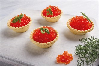 Tartlets with red caviar, on a light background, close-up, top view, no people