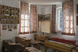 Retro classroom with wooden furniture, simple curtains and plenty of daylight through windows,