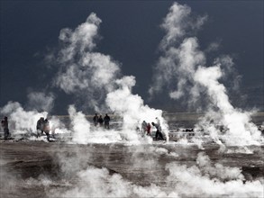 People walking between geysers in the Atacama Desert, Chile, South America