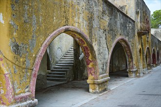 An old wall accompanied by arches showing signs of historical decay and deterioration, Italian