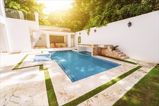 Homemade swimming pool surrounded by trees. Beautiful crystal clear swimming pool in a backyard.