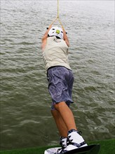 Young man with wakeboard at the jump start, water sports in the wakepark