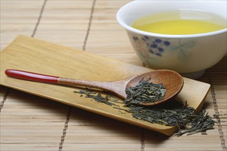 Green Sencha tea in tea bowl and tea leaves in wooden spoon, green tea, Japan, Asia