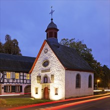 Illuminated St Mary's Chapel in the evening with traces of light from passing cars, Rhöndorf, Bad