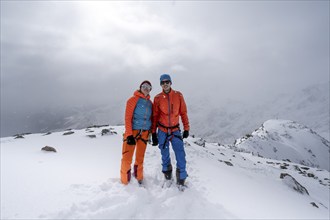 Two ski tourers, couple on the summit of the Köllkuppe or Cima Marmota, snow-covered mountain