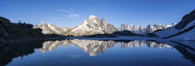 Mountain landscape in the evening light, water reflection in Lac Blanc, mountain hut Refuge du Lac