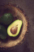 Fresh, sliced avocado, in a wooden plate, top view, food background, concept, food styling