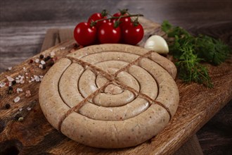 Raw spiral sausages, on a wooden board, top view, no people