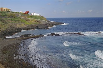 The coastline with gentle waves, houses and rocky surroundings, San Andres, La Palma, Canary