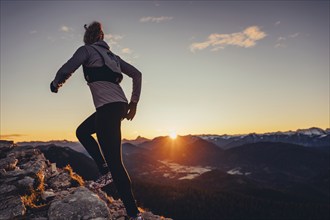 Trail running in autumn on the Jochberg on Lake Walchensee against the wonderful backdrop of the