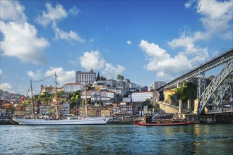 View of Porto city and Douro river with traditional boats with port wine barrels and sailing ship