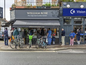 People queueing outside William Rose butchers, East Dulwich, London, England, Uk