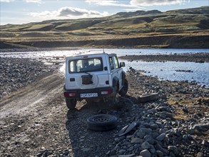 4x4 car with flat tire, change of tire at river crossing on mountain road F206, road to Laki crater