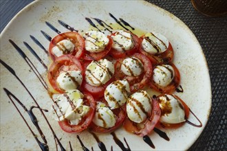 Italian cuisine, Insalata Caprese, vine tomatoes, buffalo mozza arranged on a plate, balsamic