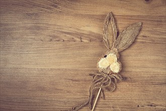 Easter bunny made of straw, on a wooden background, top view, no people