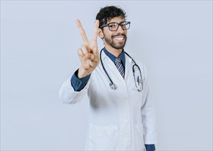 Doctor counting number two isolated. Smiling young doctor counting number 2 on isolated background