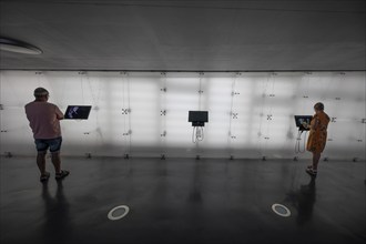 Visitors inform themselves on screens about the Air and Space Museum, Friedrichshafen,