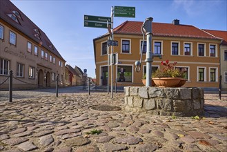 Historic public hand pump, signpost to the museum and Marienstern Monastery, Mühlberg Elbe,