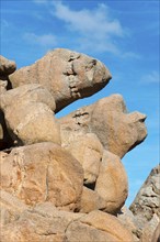 Large, eroded rock formations under a blue sky are reminiscent of faces, Ploumanac'h, Ploumanach,