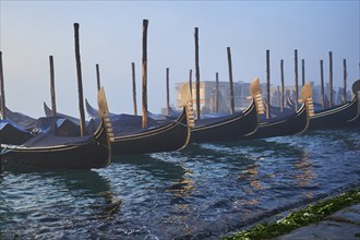 View from 'Colonna di San Marco e San Teodoro' on the gondolas lying in the water at sunrise in