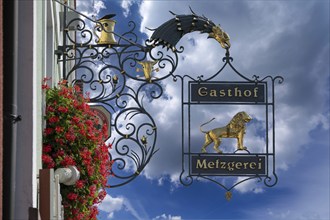 Nose sign of the Goldener Löwe inn and butcher's shop, behind the church of the Assumption of the