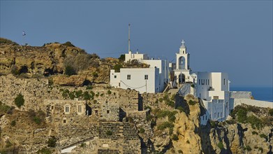 White church and building on a cliff overlooking the Mediterranean Sea on a sunny day, morning