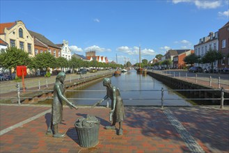 Old harbour with the bronze sculpture 'Törfwieven' in Weener, East Frisia, Lower Saxony, Germany,