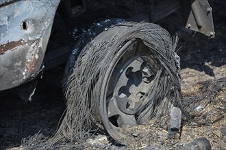 Close-up of a burnt wheel that is completely destroyed and covered in ash, forest fires, summer